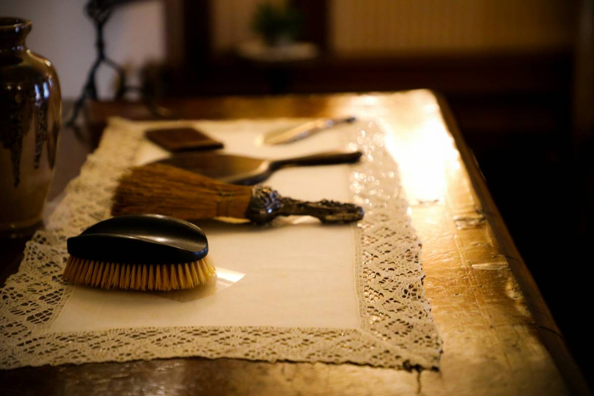 Woman struggling to brush her golden retriever's matted fur indoors